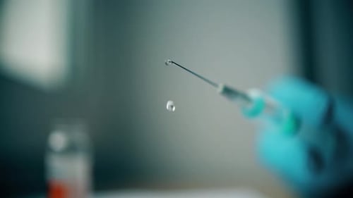 Close Up of Liquid Dripping from Syringe Needle