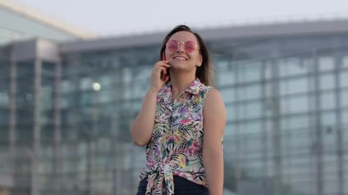 Woman Talking on Phone Outside Airport