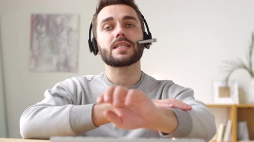 Friendly Young Man Explaining Something Wearing Headset