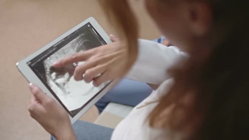 Woman Looking at Ultrasound Scan Picture on Tablet