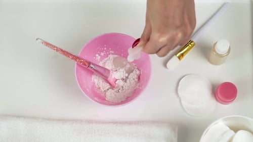 Close Up of Professional Beautician Makes a White Clay Mask She Mixes It a Pink Bowl