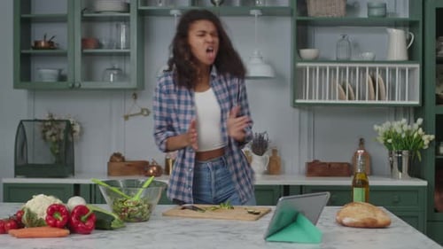 Young Woman Dancing in Kitchen While Cooking