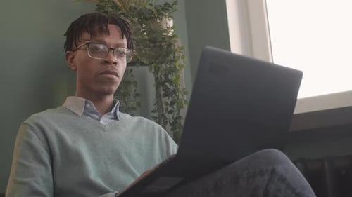 Young Adult Working on Laptop at Home