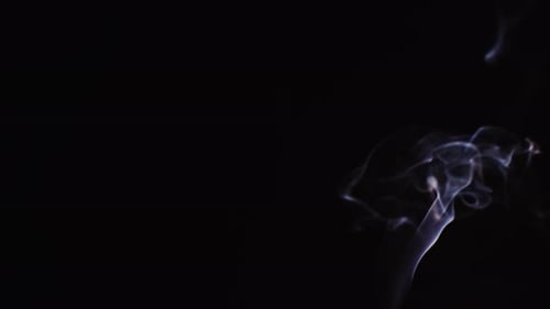 Realistic cloud smoke with a streamlined pattern. Abstract blue smoke on dark background in slow mot