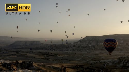 Balloons Floating Above Landscape at Sunrise