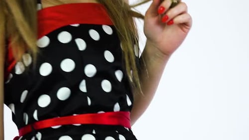 Cheerful Woman in Polka Dot Dress Styling Hair
