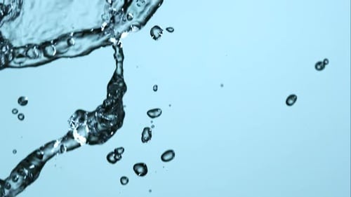 Water Splashing and Dropping on Light Blue Background