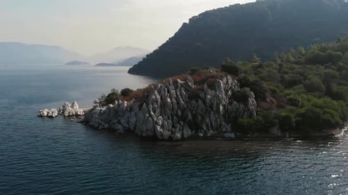 Rocky Coast of the Island in the Open Sea. White Rocks on the Shore of the Island. Aerial View