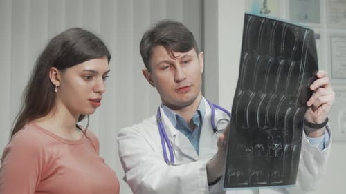 Doctor Explains X-Ray to Patient in Office