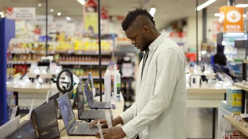 The Buyer Chooses a Laptop in a Modern Technology Store