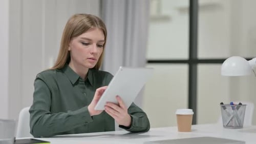 Woman Uses Tablet at Desk in Office