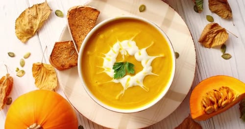 Cremige Kürbissuppe in Schüssel mit Kräutern