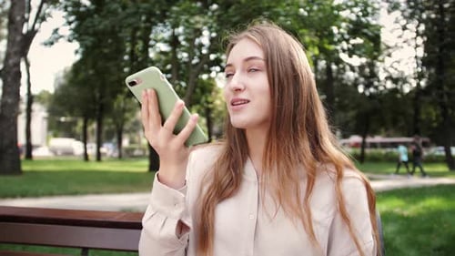 Woman Using Voice Command on Phone in Park