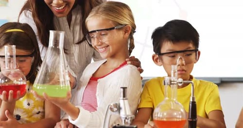 School kids doing a chemical experiment in laboratory