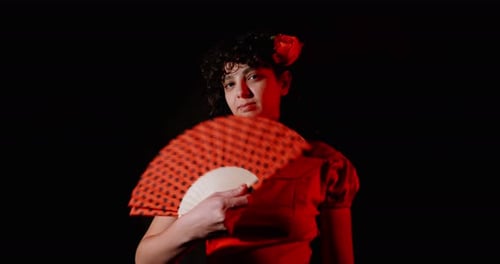 Woman Posing With Hand Fan on Black Backdrop