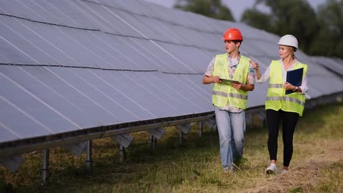 Engineers Inspecting Solar Panels on a Solar Farm