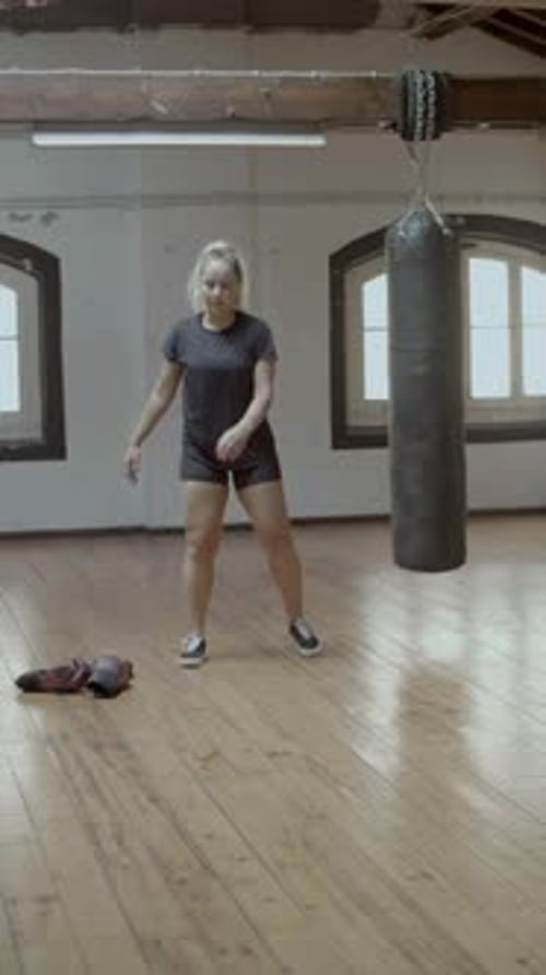 Blonde Woman Stretching and Warming Up in Gym