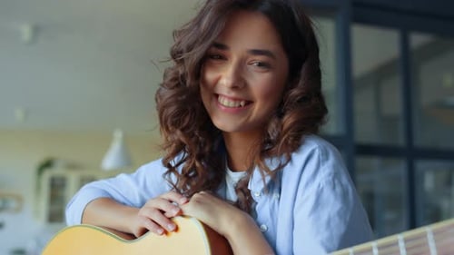 Smiling Woman Holding Guitar Indoors