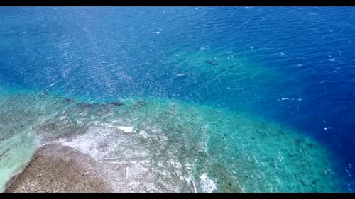 Aerial flying over panorama of marine shore beach holiday by blue ocean with white sandy background