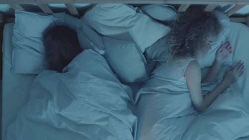Woman Messaging while Husband Sleeping