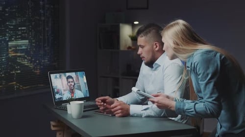 Videoconferência estendida entre dois diretores no computador tarde da noite