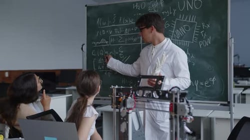 Professor Explains Robotics to Students in Classroom