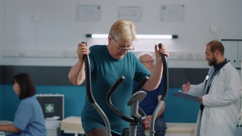Senior Woman Exercising on Elliptical in Rehabilitation Clinic