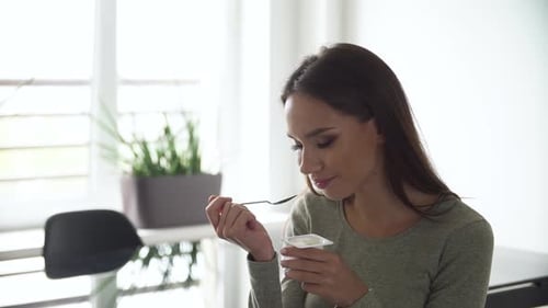 Woman Eating Yogurt at Home