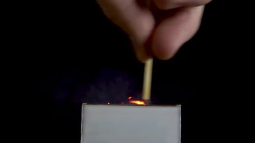 Match Ignites Against Dark Background