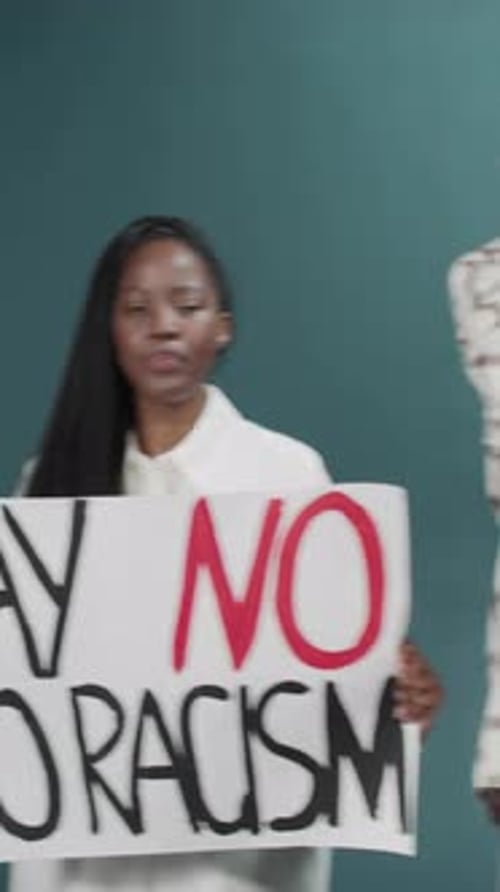 Group Holds Signs Against Racism in Studio