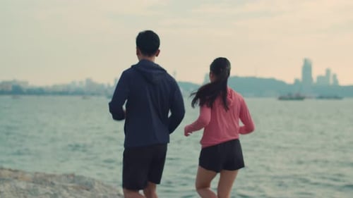 Attractive sporty young fitness couple wearing sportswear working out outdoors at the beach.