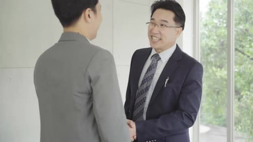 Businessmen Greeting Each Other With Handshake and Hug
