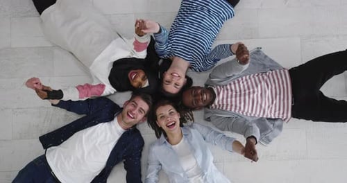 Friends Lying in Circle, Holding Hands, Overhead Shot