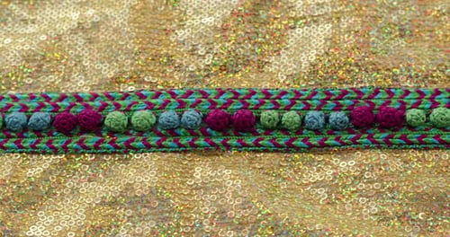 Motif de couleur tricoté sur tissu doré brillant avec gros plan à paillettes