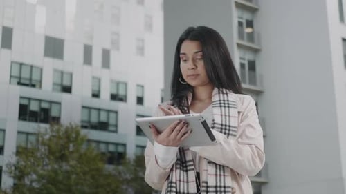 Businesswoman Working on Digital Tablet in City. Pretty Girl Using Pad on Street