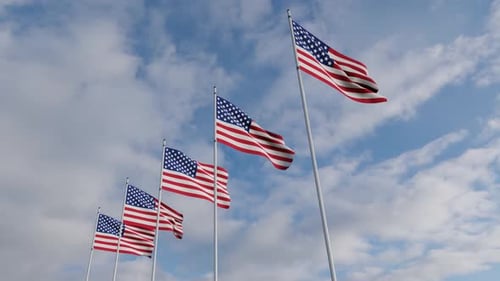 Five American Flags Waving in Wind Against Blue Sky