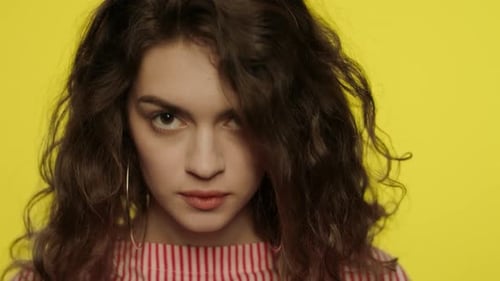 Shocked Woman Open Mouth. Shock Girl Closing Mouth with Hands in Yellow Studio