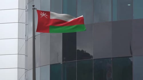 Waving Flag of Oman on a Pole Against a Modern Building