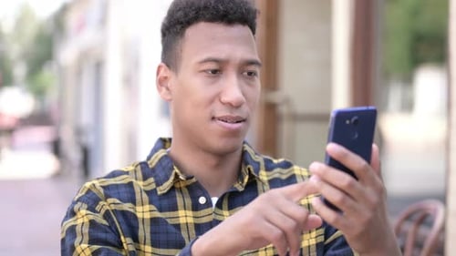 Young Man Using Smartphone in Urban Setting
