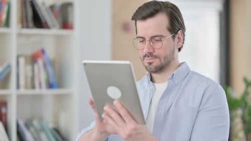 Young Adult Using Tablet Indoors