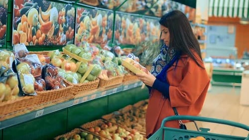 Mulher feliz fazendo compras no supermercado