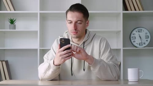 Male Professional Holding Smartphone Texting Message in Office