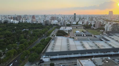 Buenos Aires drone view orbiting La Rural Exposition centre urban skyline cityscape at sunset