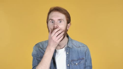 Man Reacts with Shock on Yellow Background