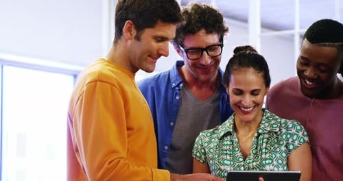 Group of business executives discussing over digital tablet