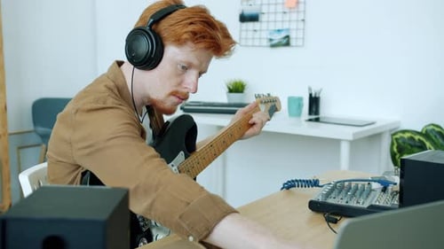 Red-Haired Musician Plays Electric Guitar in Studio