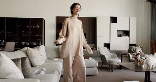 Stylish Woman Dances in a Modern Living Room