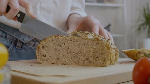 Slicing Whole Grain Bread in Kitchen
