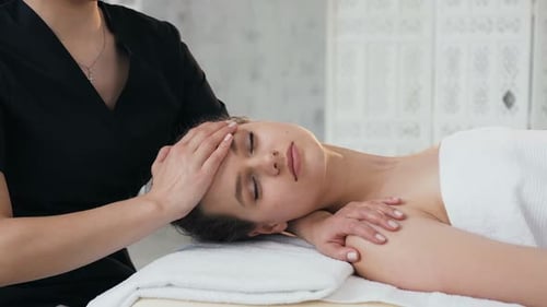 Woman Receiving Relaxing Face and Neck Massage at Spa