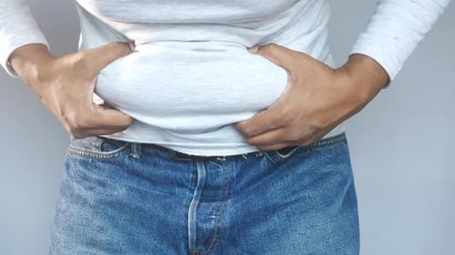 Adult Showing Fat Around Waist with Hands